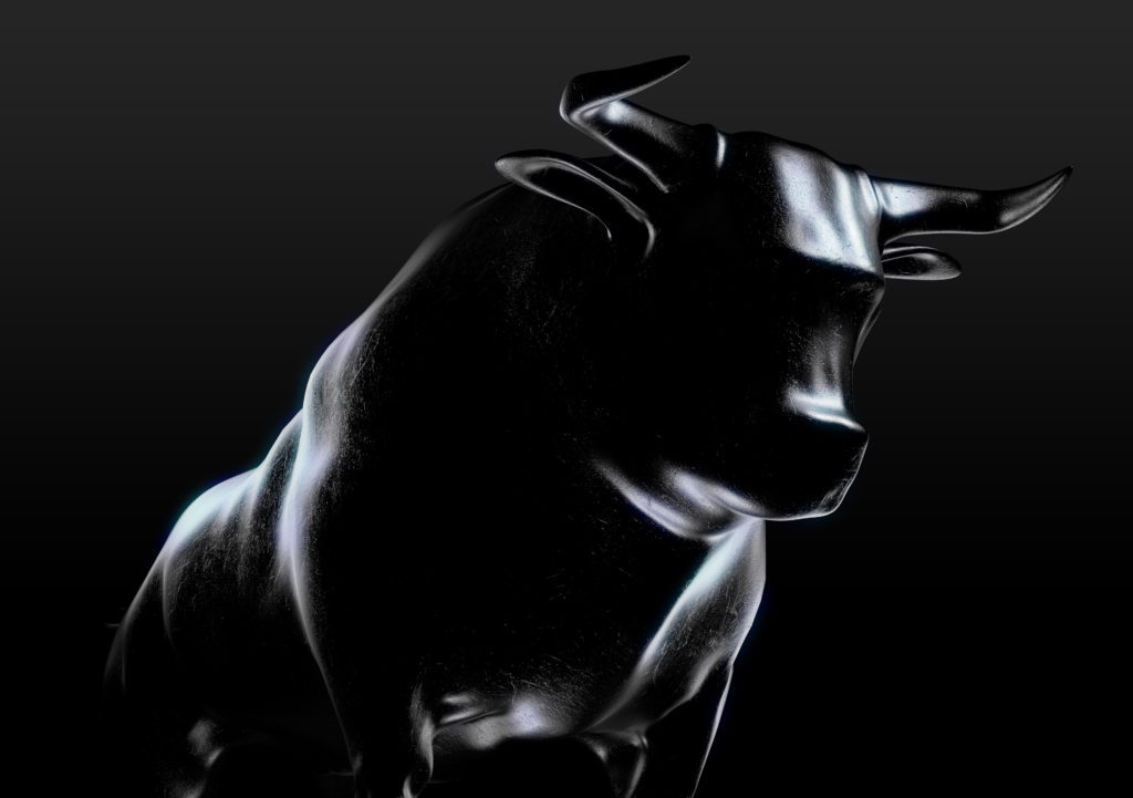 A sculpted casting depicting a bull in dramatic contrasting light representing financial market trends on an isolated dark background - 3D render