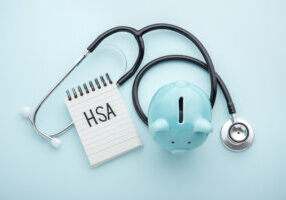 Health saving account, hsa concept, piggy bank with stethoscope on pastel blue background, top view